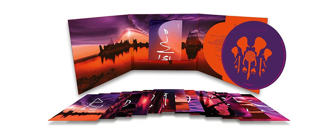 Ein CD-Set mit Kunstwerken, die eine Sonnenuntergangsszene und stilisierte Figuren zeigen. Mehrere Karten und ein Booklet sind sichtbar.