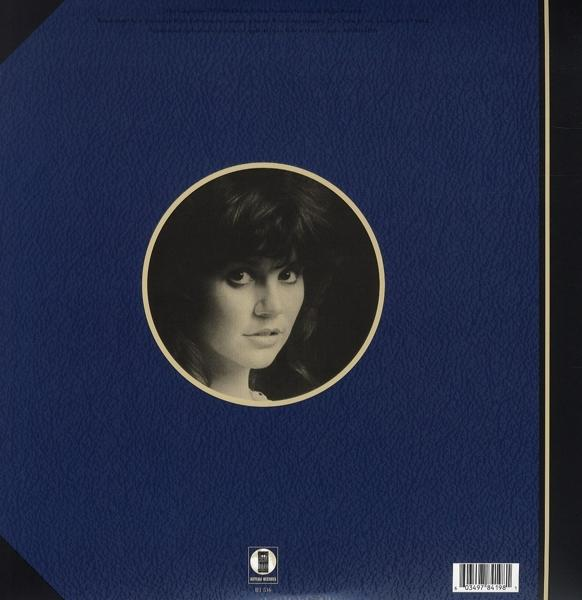 Blaues Albumcover mit Porträt im Kreis und weißem Rand.