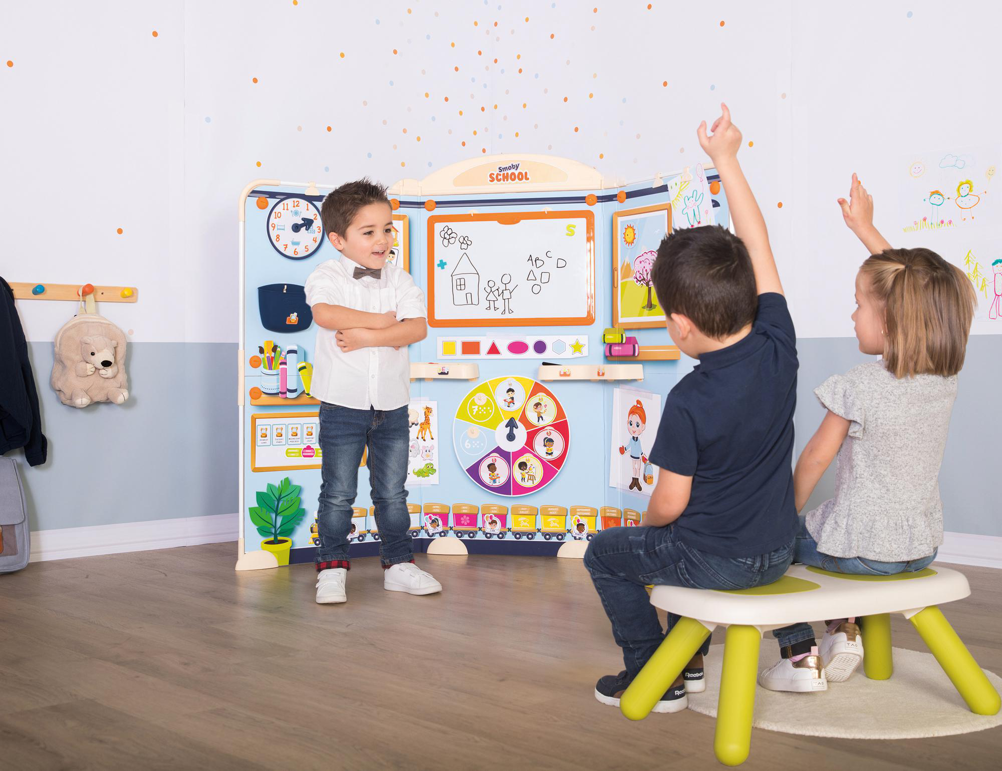 Kinder in einem Klassenzimmer, mit einer Schultafel und bunten Lernwerkzeugen.