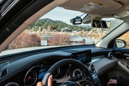 Vue de l'intérieur d'une voiture, regardant un lac et des arbres.