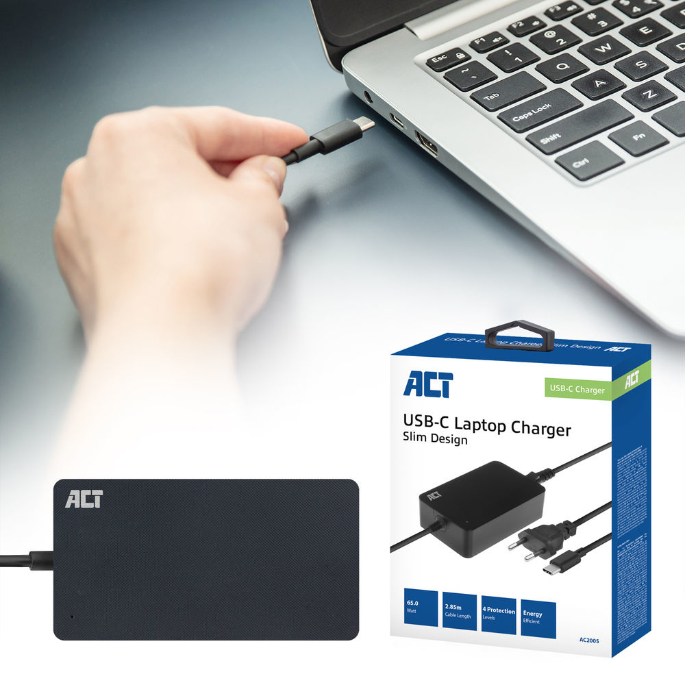 Une main branche un câble USB-C sur un ordinateur portable. Un chargeur et une boîte pour ordinateur portable sont en arrière-plan.