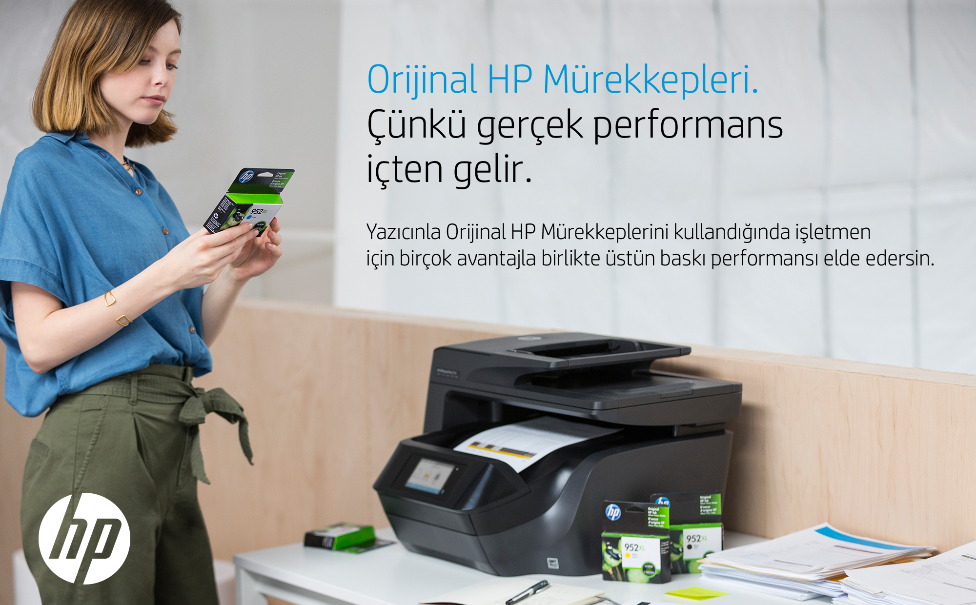 Kadın, bir yazıcının yanında mürekkep kartuşları tutuyor. Türkçe metin, HP logosu görünür.