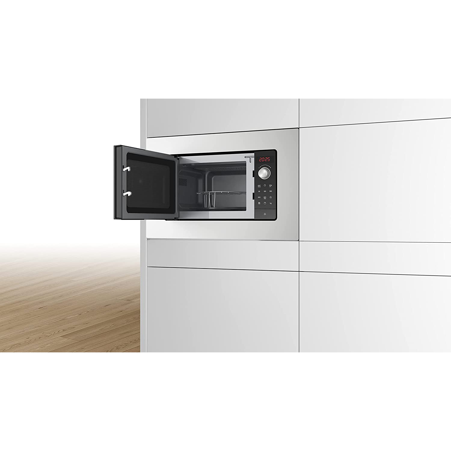 Forno a microonde in un mobile bianco. Porta aperta. L'ora è visualizzata.