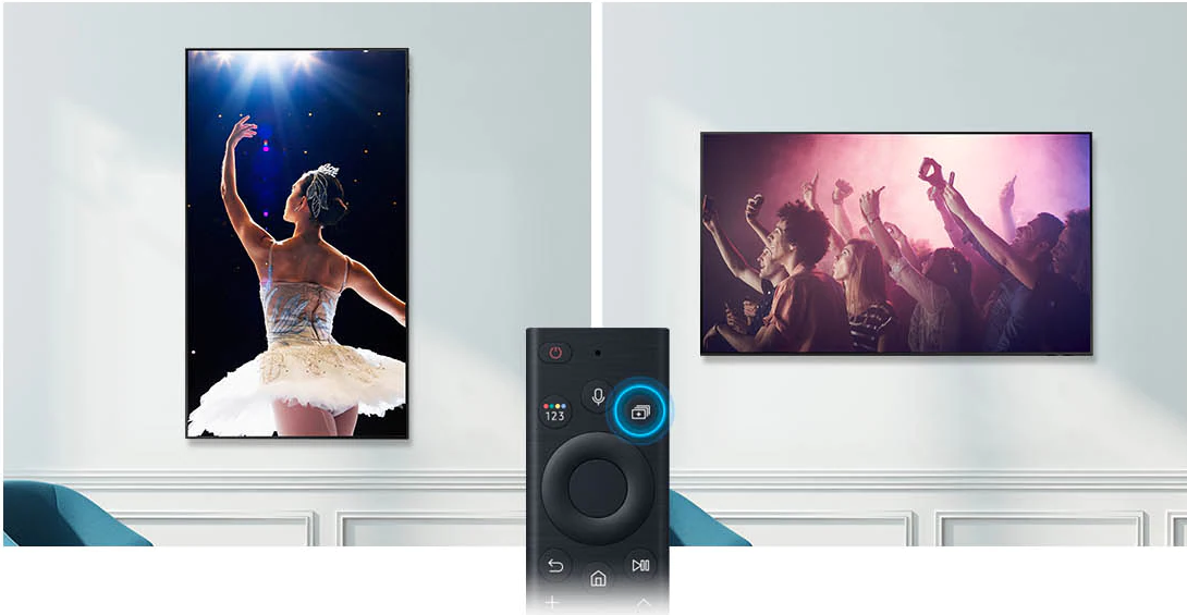 Zwei Fernseher an der Wand. Einer zeigt eine Ballerina, der andere eine Menschenmenge. Eine Fernbedienung.