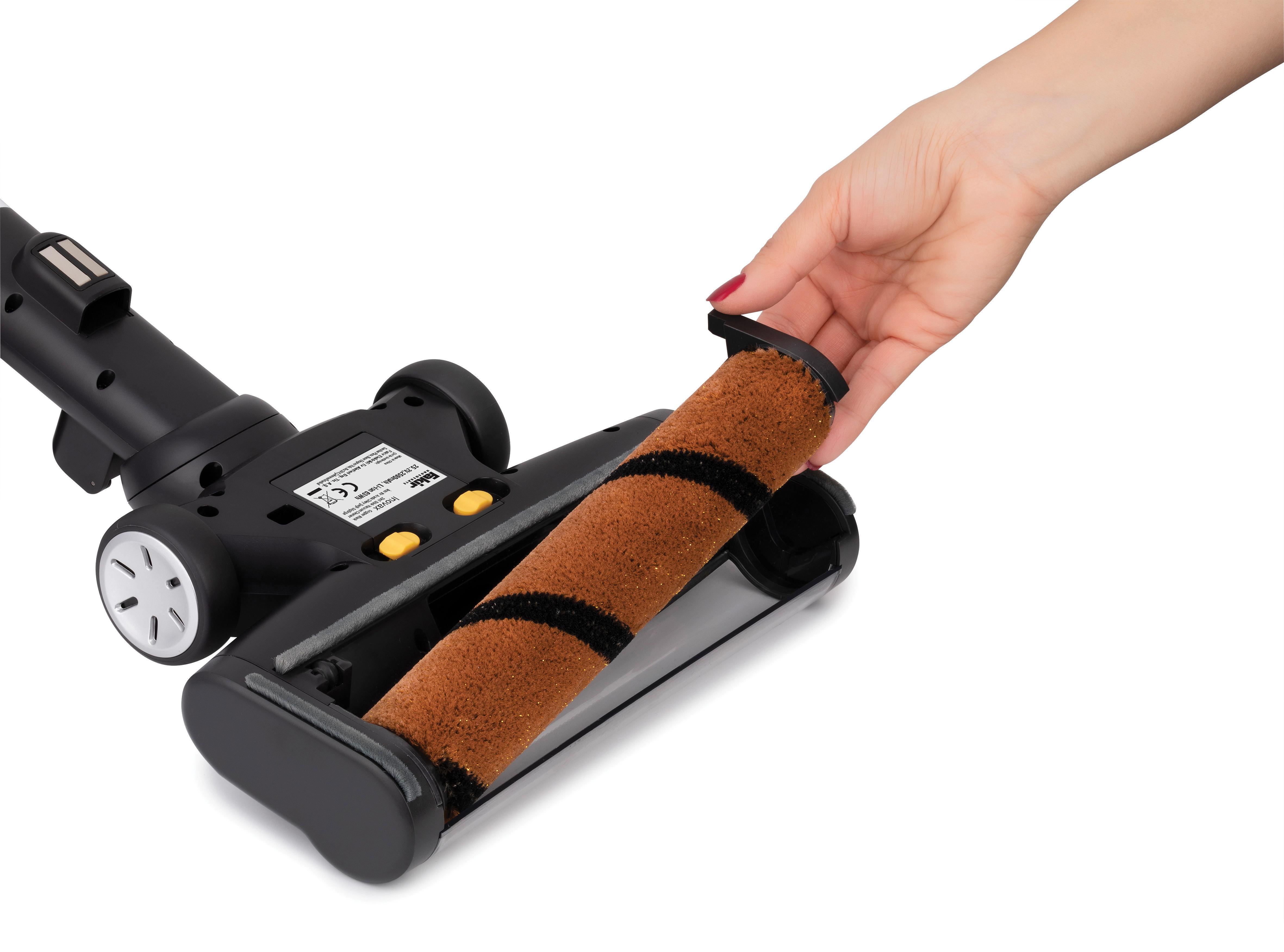 Hand entfernt Bürstenrolle aus einem schwarzen Staubsauger.