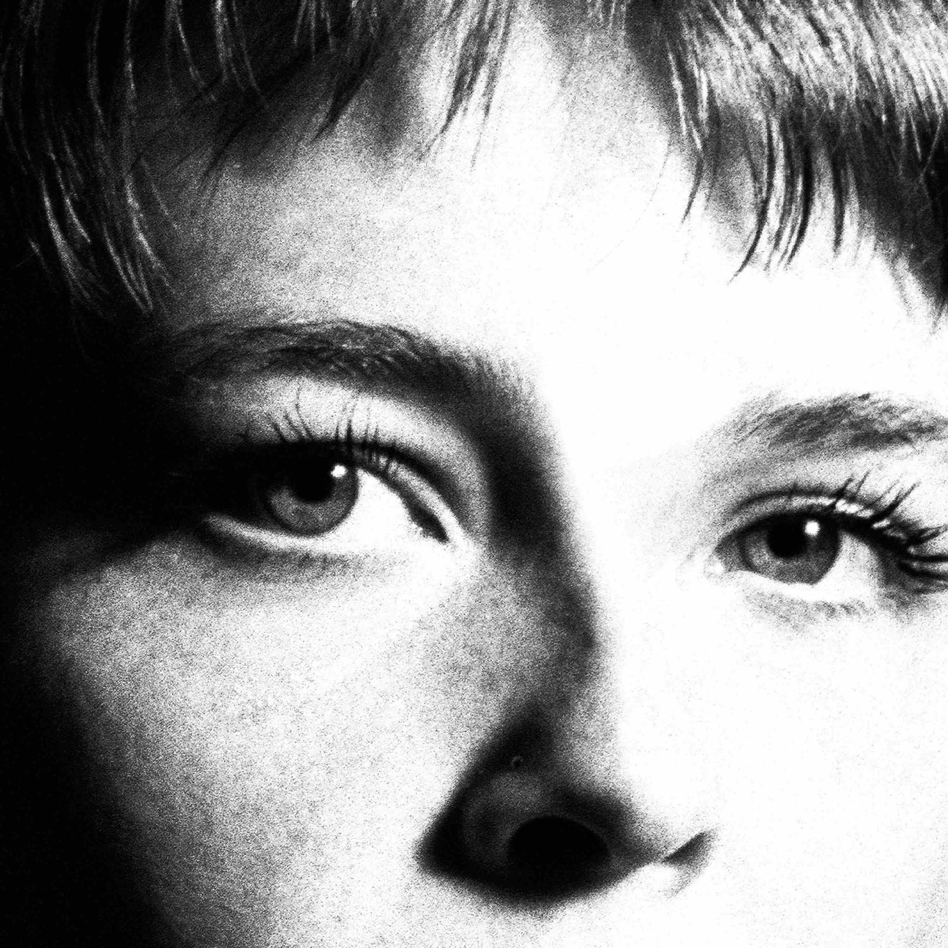 Schwarz-Weiß-Nahaufnahme eines menschlichen Gesichts, wobei der Fokus auf Augen und Nase liegt.
