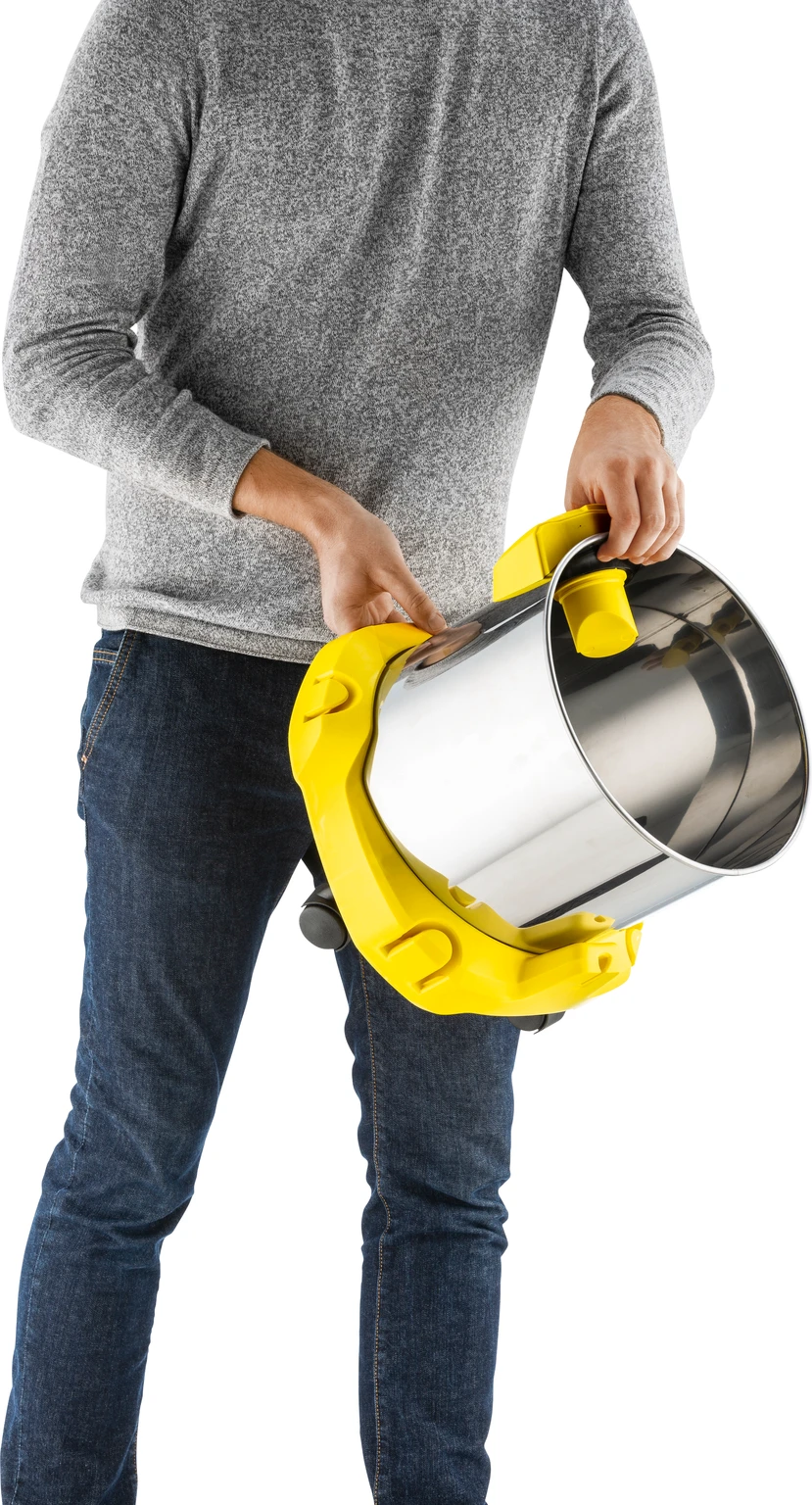 A man holding a yellow vacuum cleaner container, showing the inside. He's wearing jeans and a grey shirt.