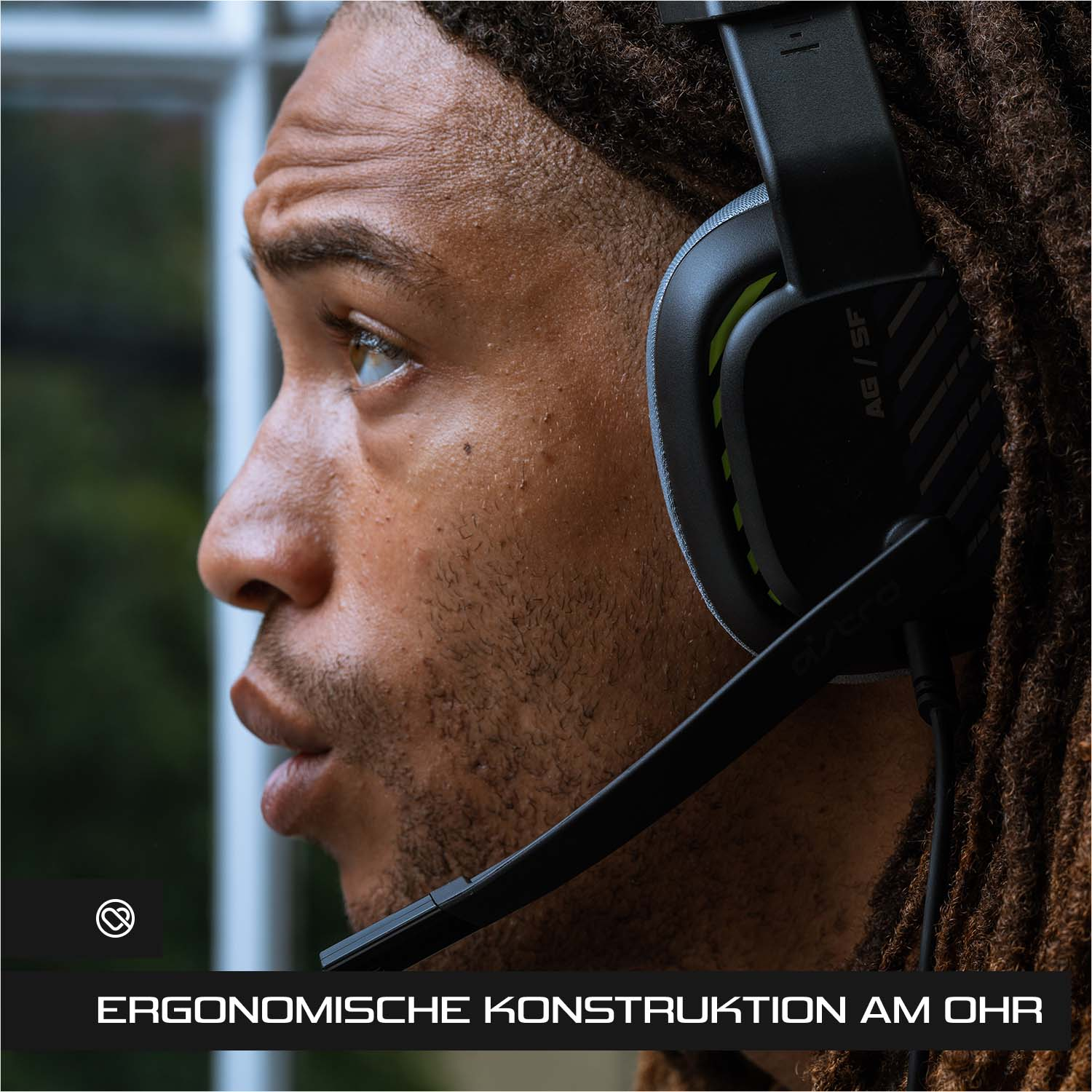 Nahaufnahme eines Mannes, der ein schwarz-grünes Gaming-Headset trägt.