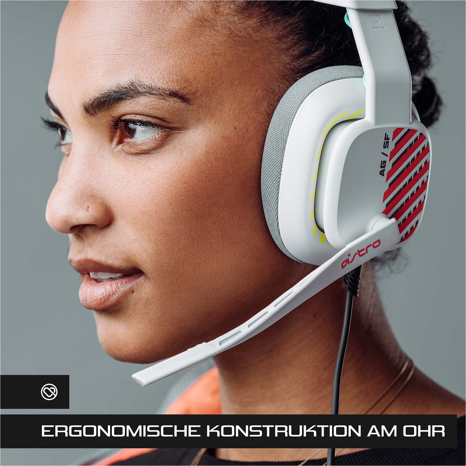 Frau mit weiß-grauem Headset. Das Headset hat ein Mikrofon, die Marke ist Astro.