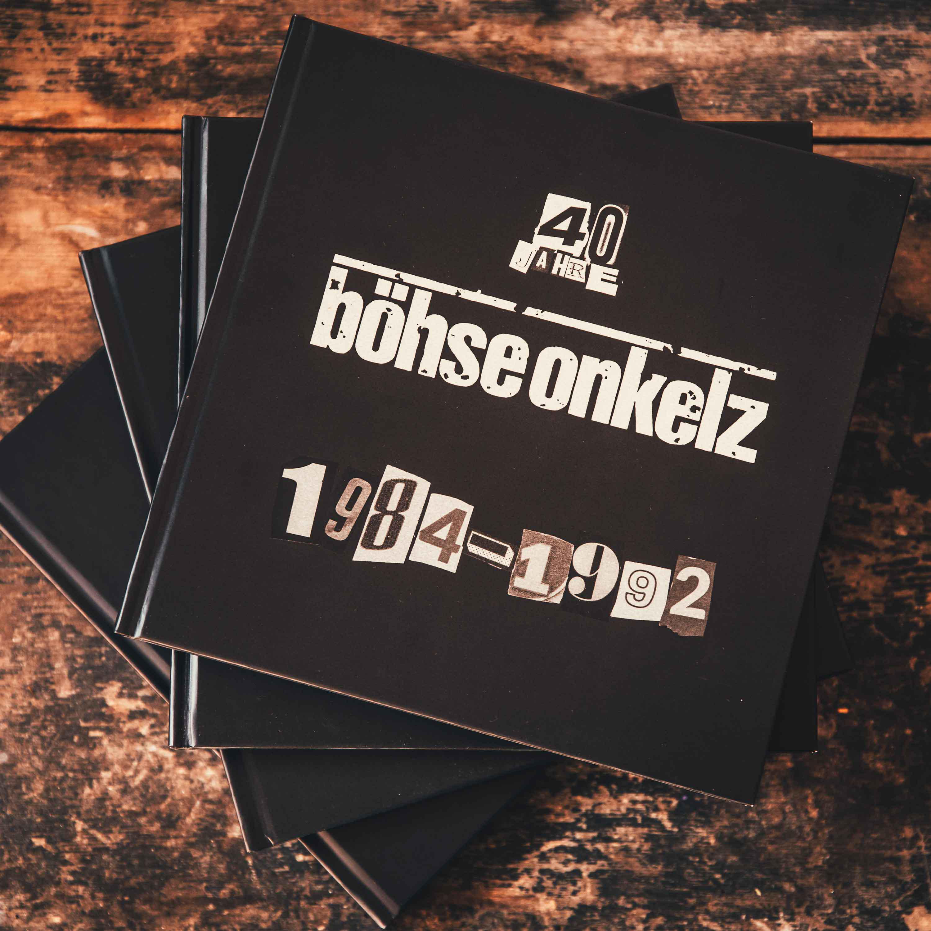 Stapel schwarzer Buchcover mit weißem Text oben und schwarzem Hintergrund.