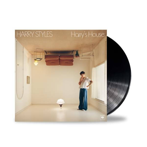 Harry Styles' Albumcover. Zeigt einen Mann in einem Raum, Möbel verkehrt herum. Das Vinyl-Album rechts.