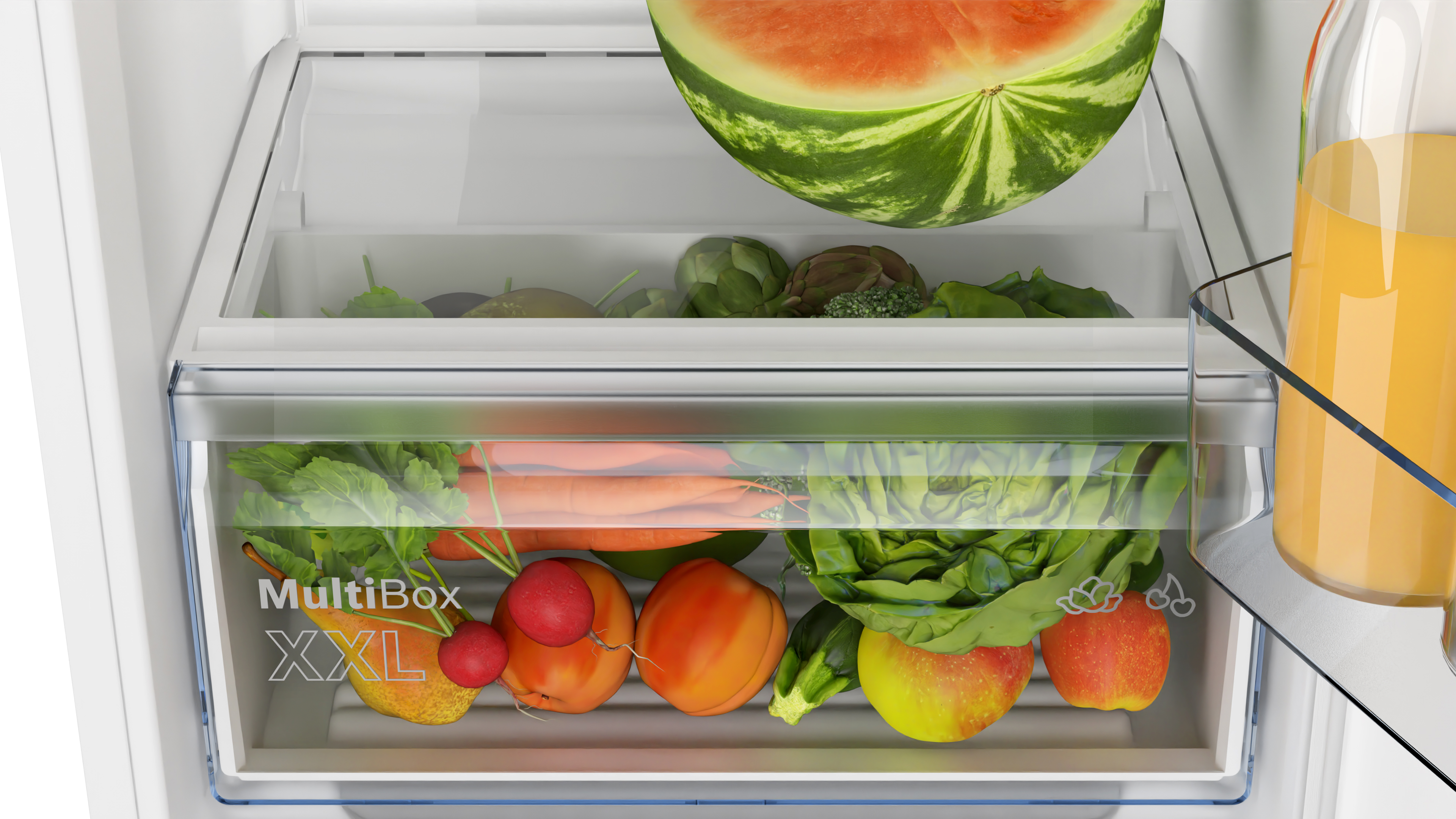 Eine Kühlschublade ist voller frischer Produkte, darunter Wassermelone und Gemüse.