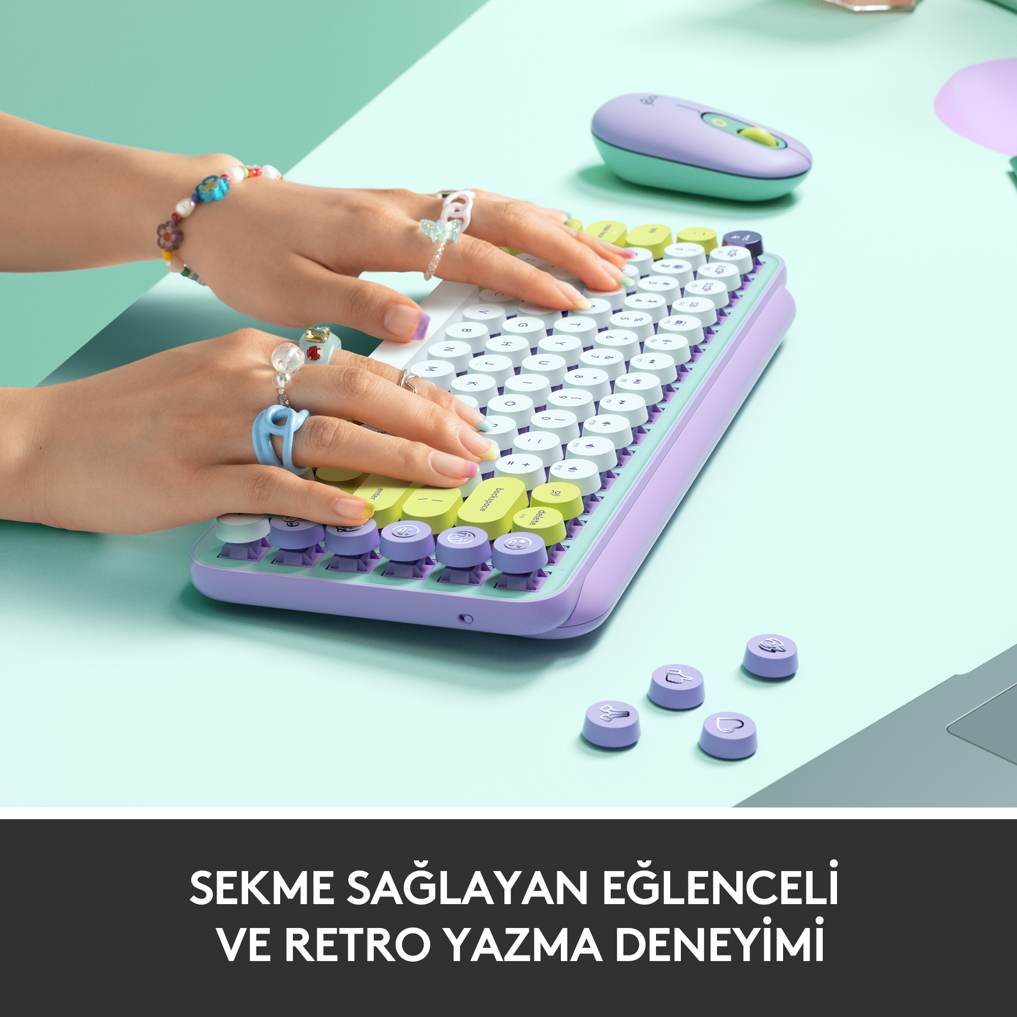 Eller, aksesuarlarla renkli bir retro klavyede yazıyor.