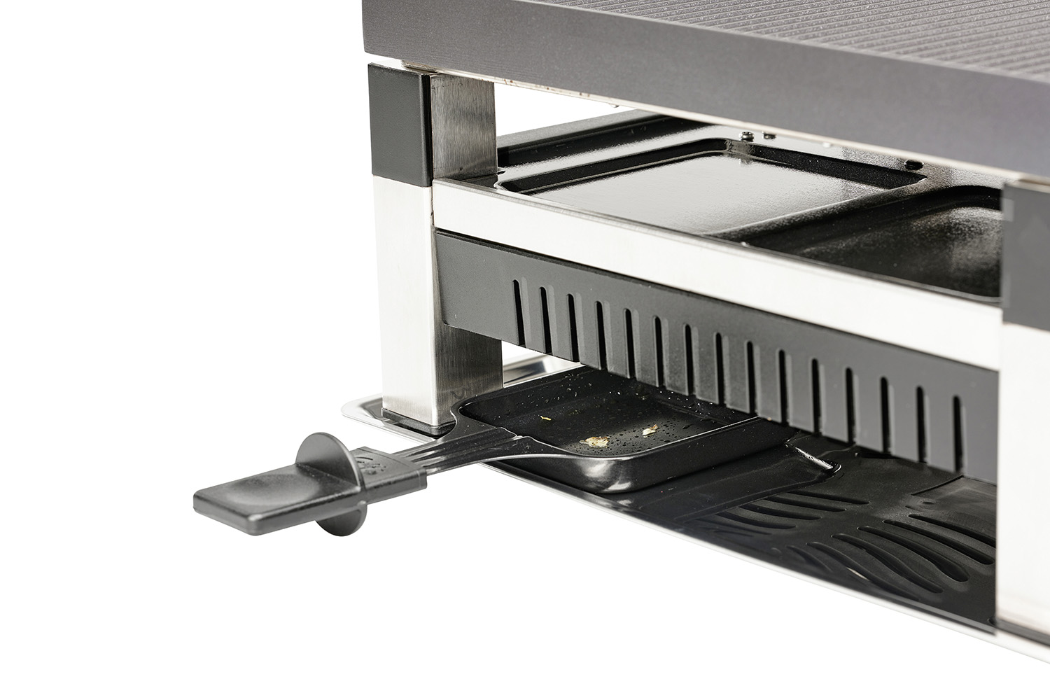 Raclette grill met bakje, handvat uitstekend, en glanzend oppervlak.