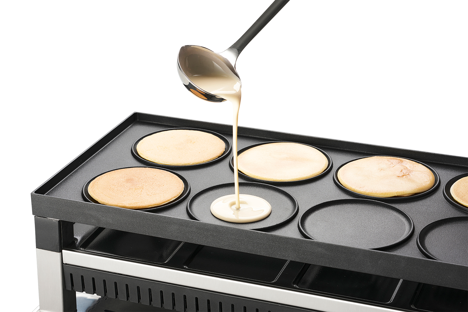 Pannenkoekenbeslag wordt op een bakplaat gegoten, met pannenkoeken die bakken.