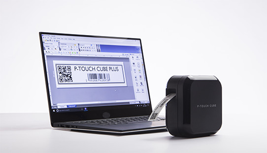 Laptop met labelontwerp, een labelprinter rechts.