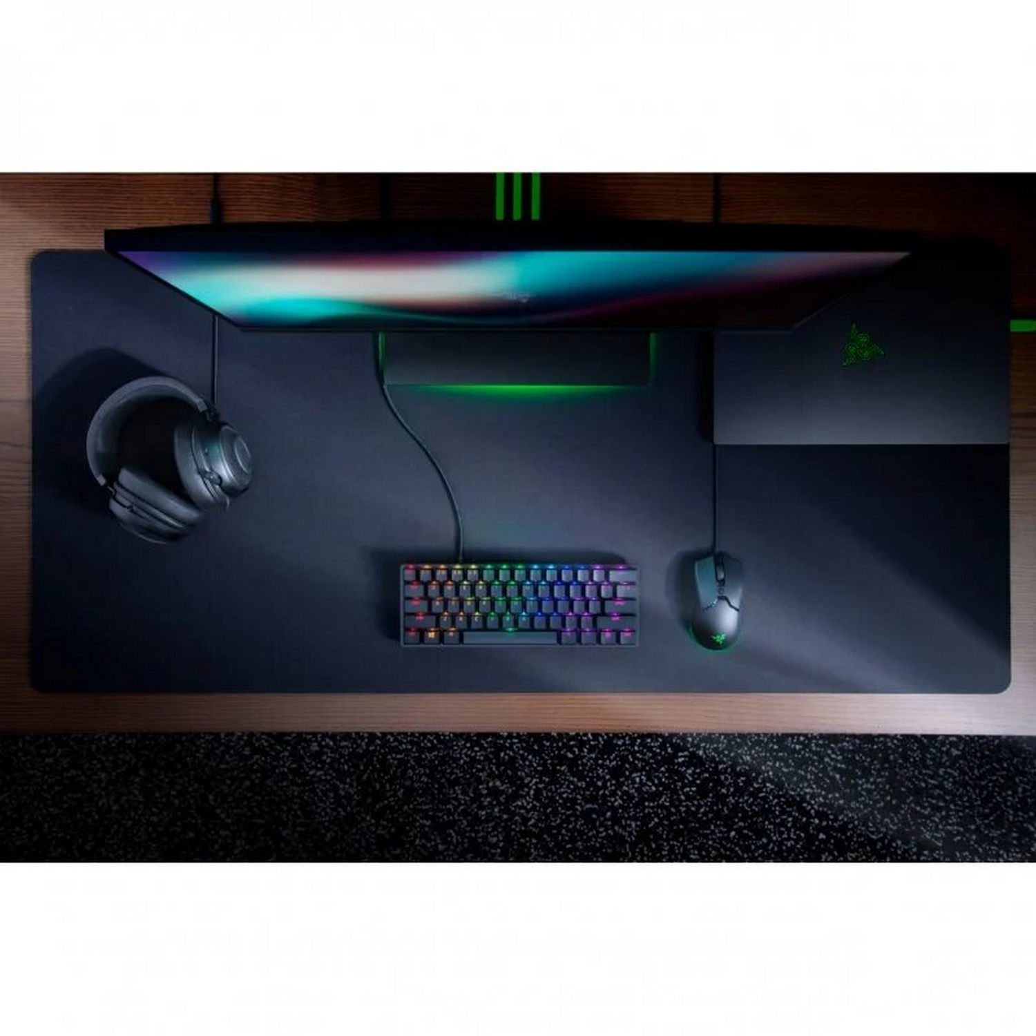 Una vista cenital de una configuración de escritorio con monitor, teclado, ratón y auriculares.