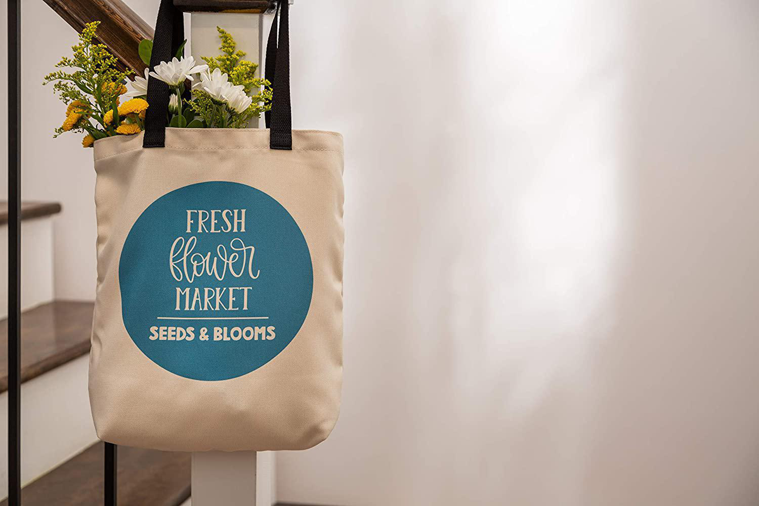 Eine Tragetasche mit Blumen steht auf einem Treppengeländer. Sie hat einen blauen Kreis mit Text.