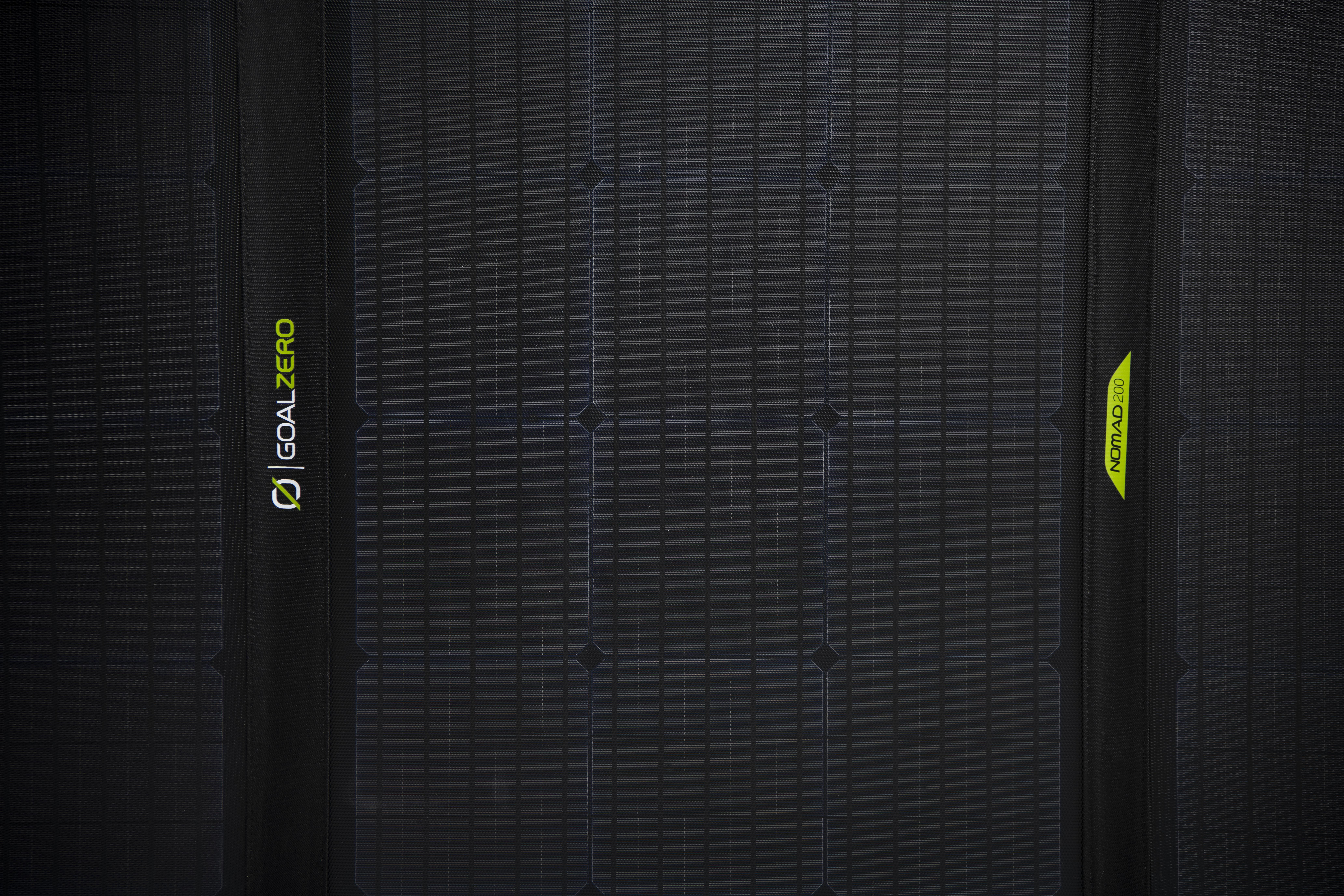 Schwarzes Solarpanel mit Logos. Grünes Goal Zero Logo. Gelbes Nomad 20 Logo.