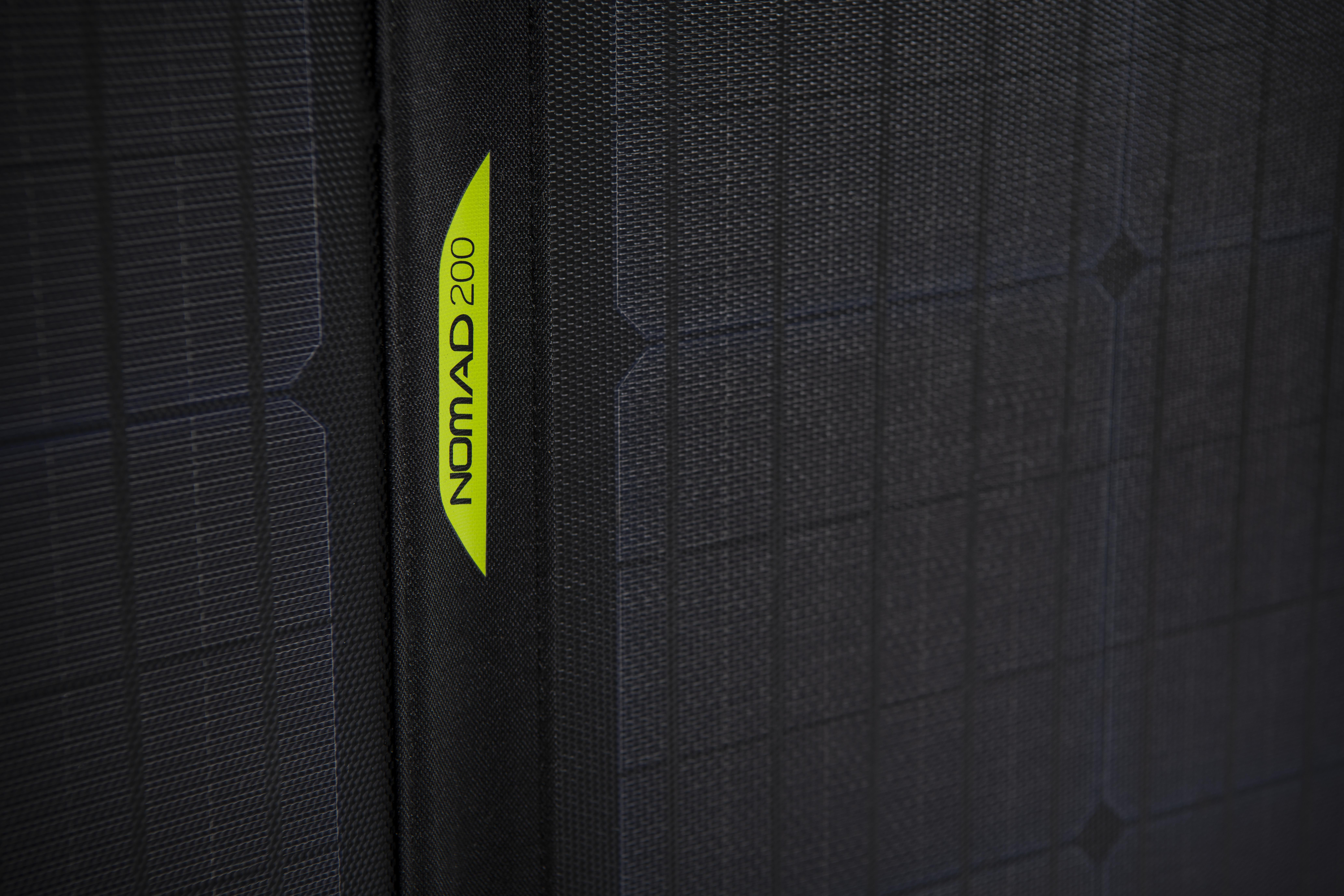 Nahaufnahme eines dunkelgrauen Solarpanels mit grünem Nomad 200-Etikett.