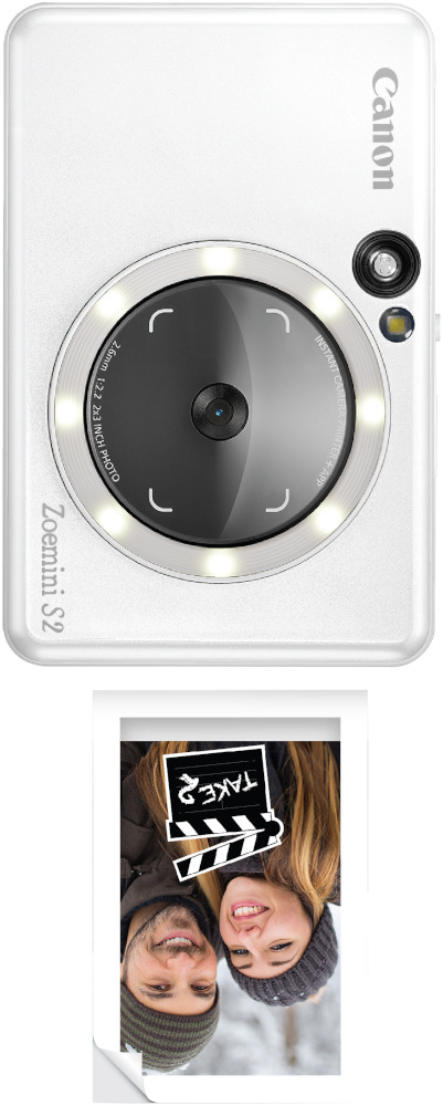 A white Canon Zoemini S2 camera and an instant photo with a couple and a 'TAKE' sign.
