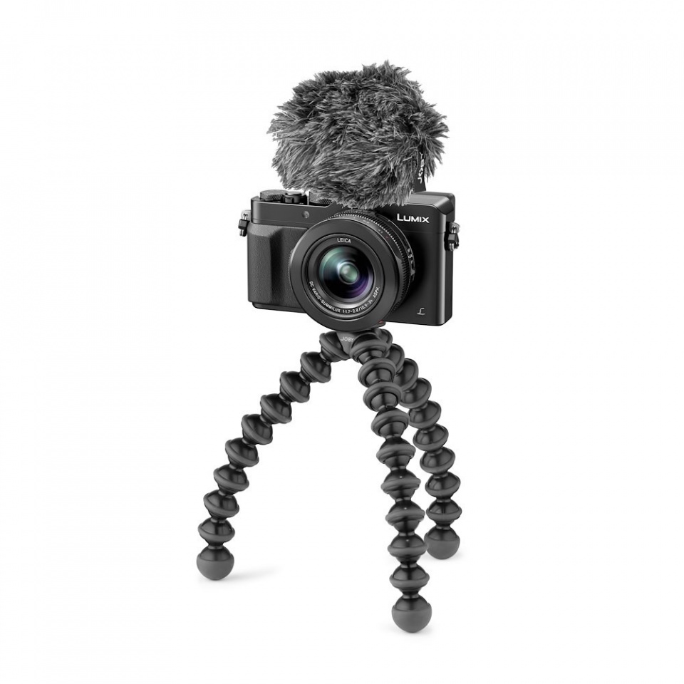 Zwarte camera op een flexibel statief met een microfoon. Witte achtergrond. Professionele opstelling.