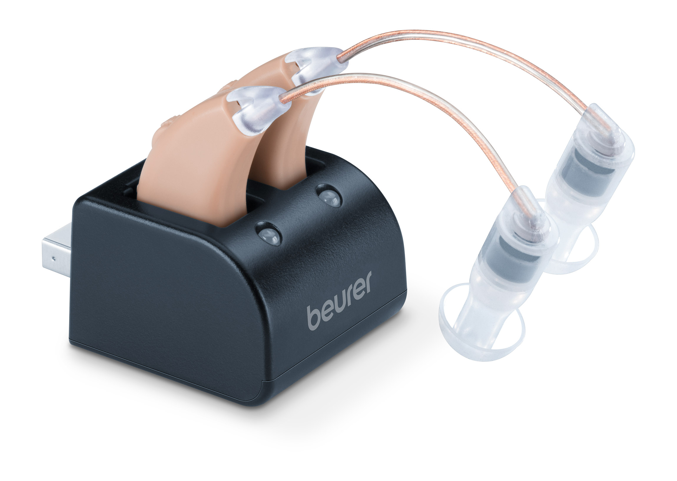 Beige Hörgeräte in einer schwarzen Ladestation mit USB-Kabel. Weißer Hintergrund.