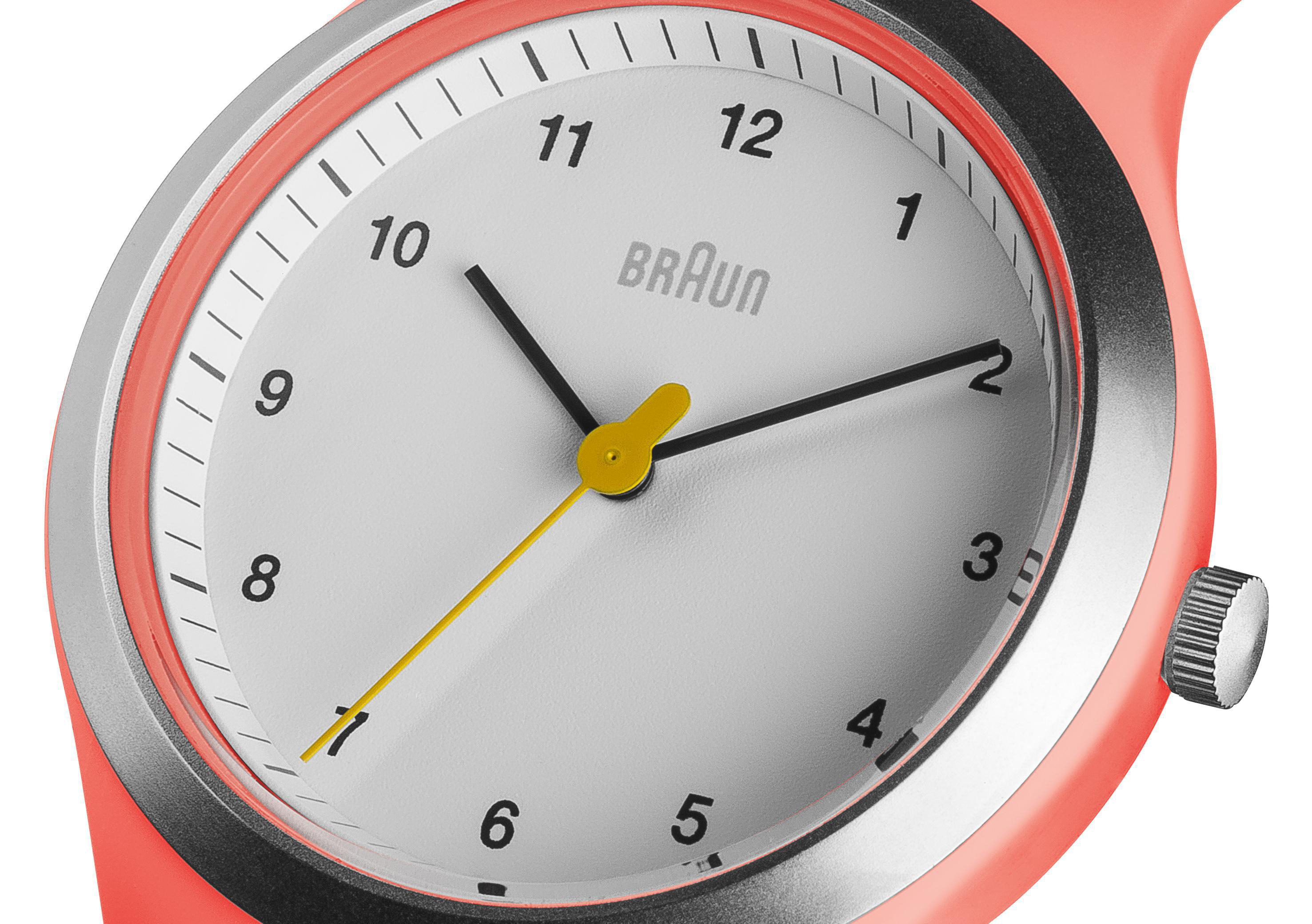 Nahaufnahme einer Braun-Uhr mit weißem Zifferblatt und korallenfarbenem Armband.