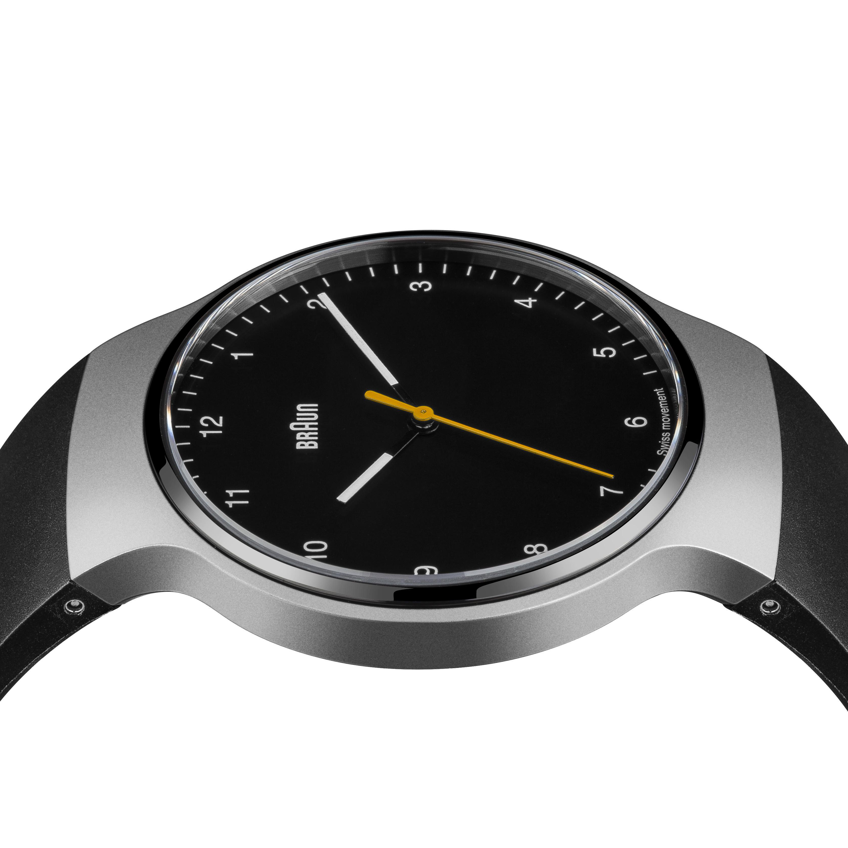 Nahaufnahme einer Braun-Uhr mit schwarzem Zifferblatt und silbernem Gehäuse. Die Zeiger sind weiß und gelb.