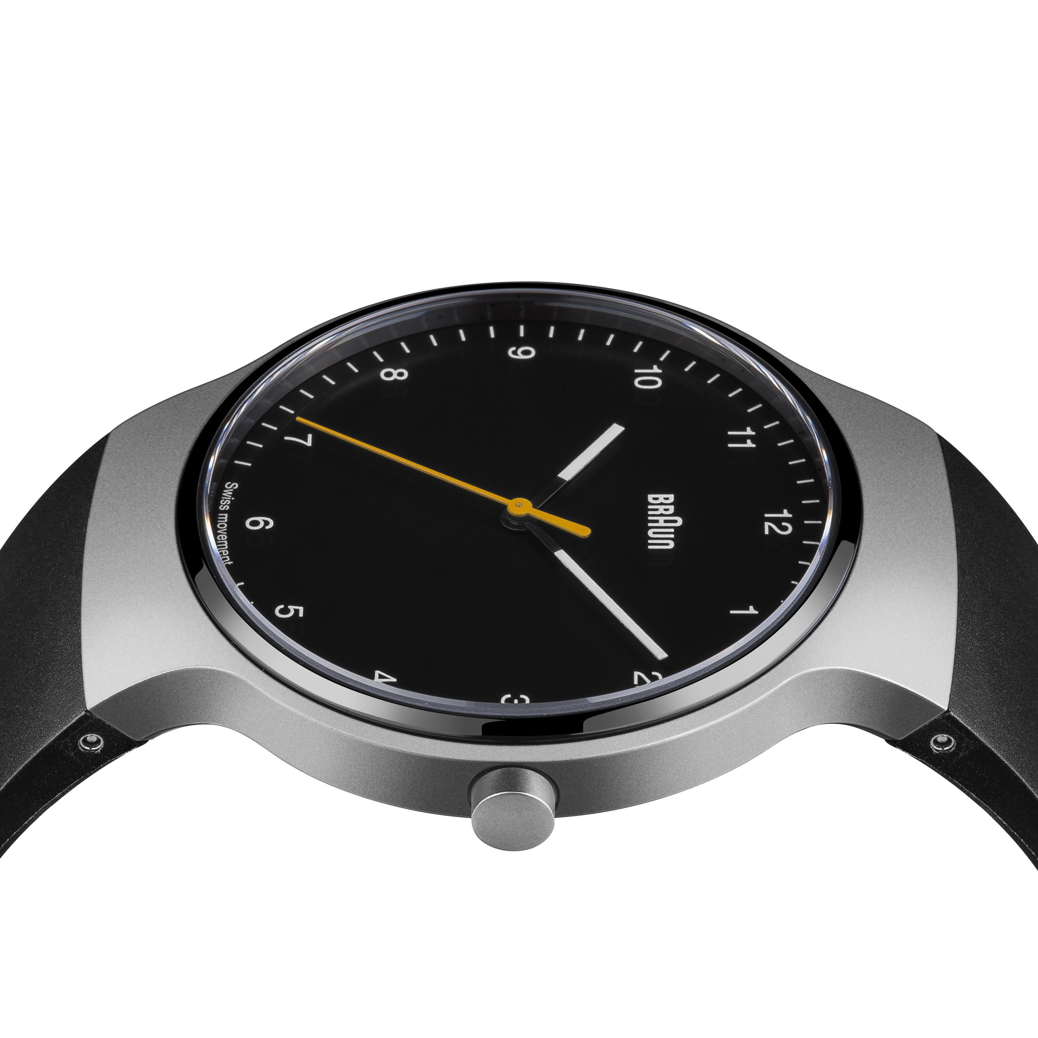Schwarze Braun-Uhr mit gelbem Zeiger an schwarzem Armband. Hintergrund: weiß.