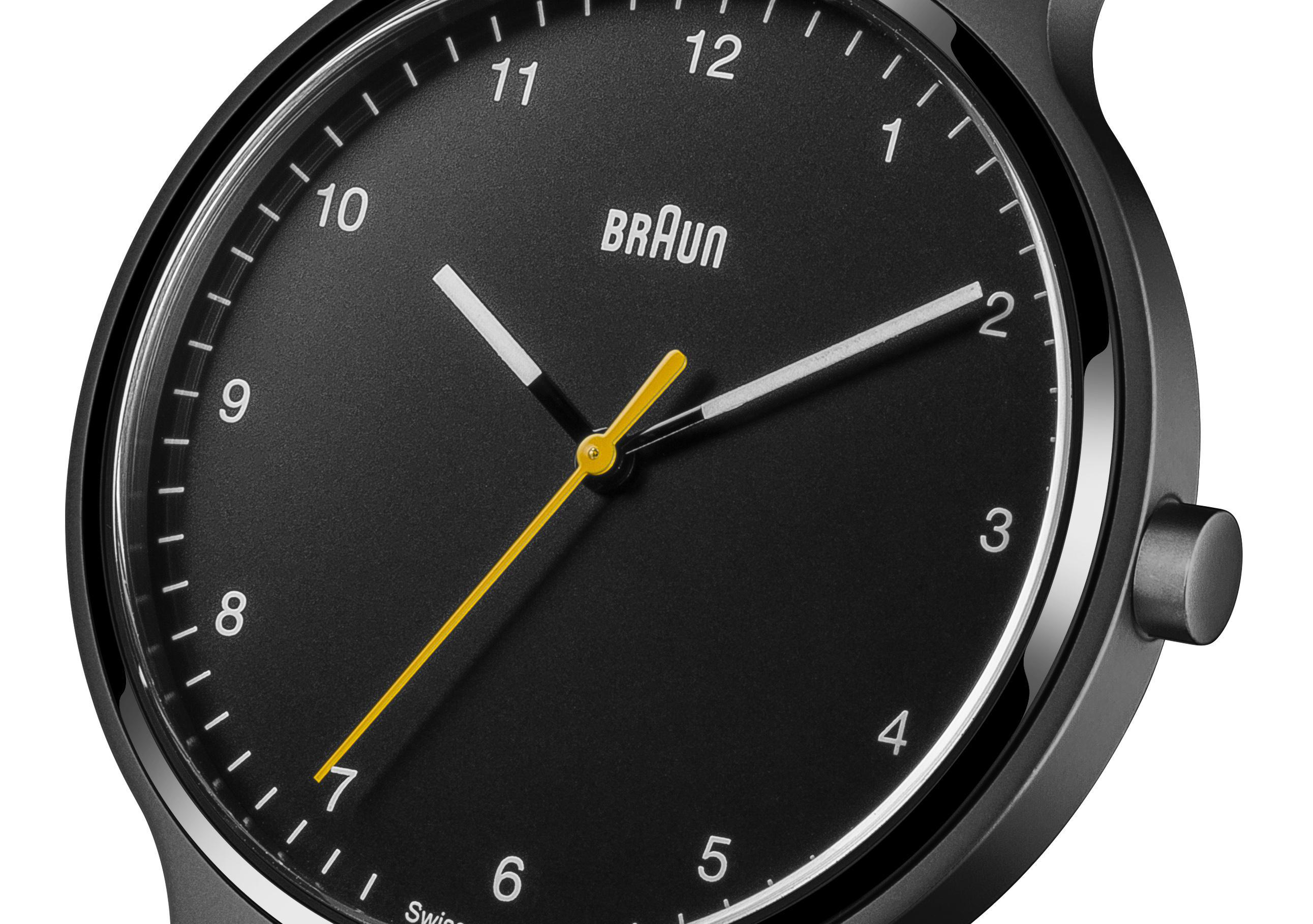 Eine schwarze Braun-Uhr mit gelbem Sekundenzeiger und dunklem Zifferblatt.