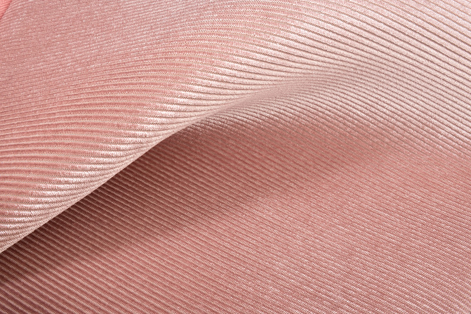 Rosa Stoff gefaltet, zeigt eine gerippte Textur. Der Stoff erscheint glatt und glänzend.