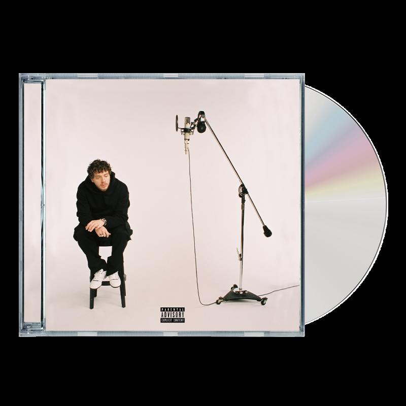 Mann, der auf einem Hocker vor einem Mikrofon sitzt, Albumcover mit CD.