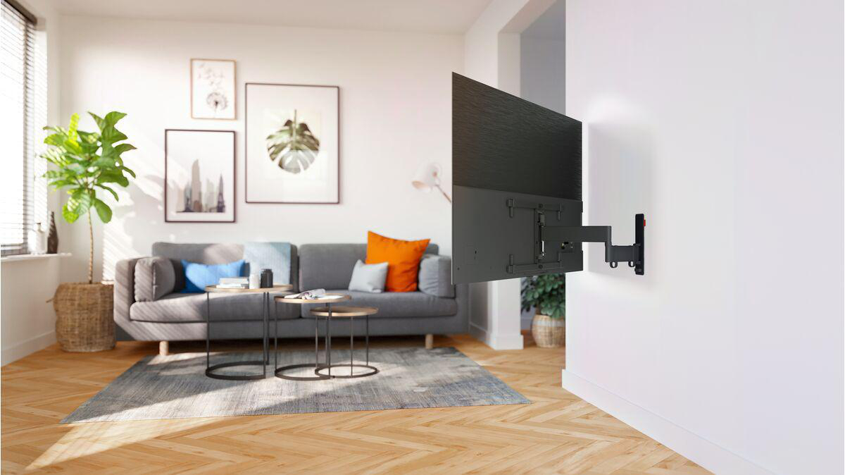 Wohnzimmer mit einem an der Wand montierten Fernseher.