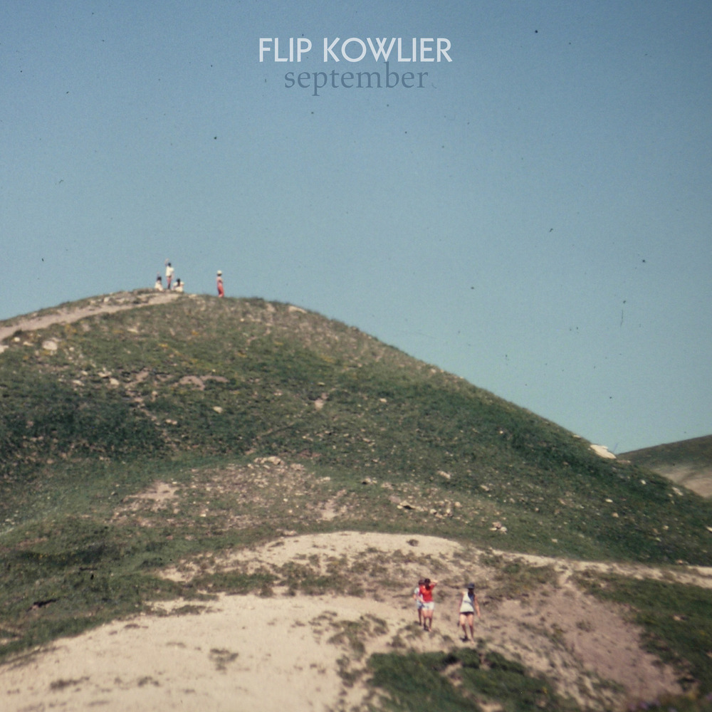 Mensen lopen op een heuvel met een blauwe hemel. Titel "Flip Kowlier september".