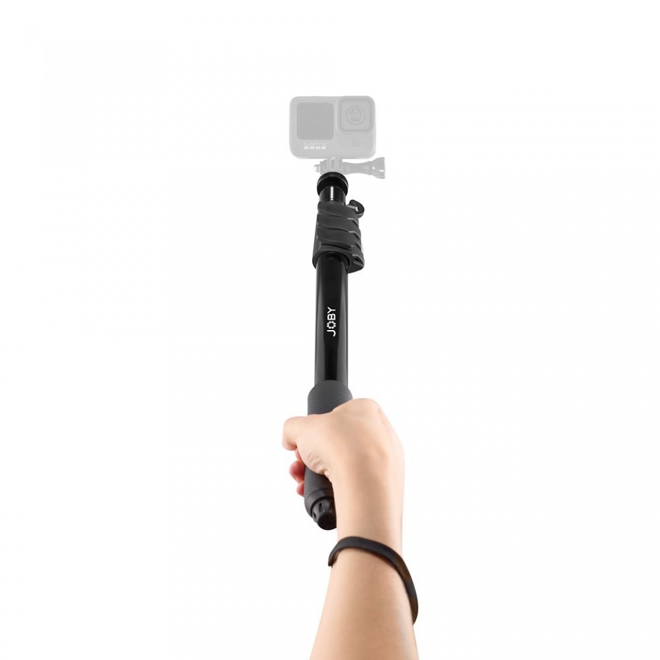 A hand holding a black selfie stick with a camera.