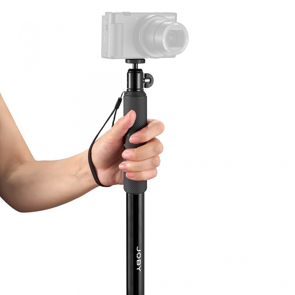 A person's hand holding a black selfie stick with a camera mounted on top, white background.