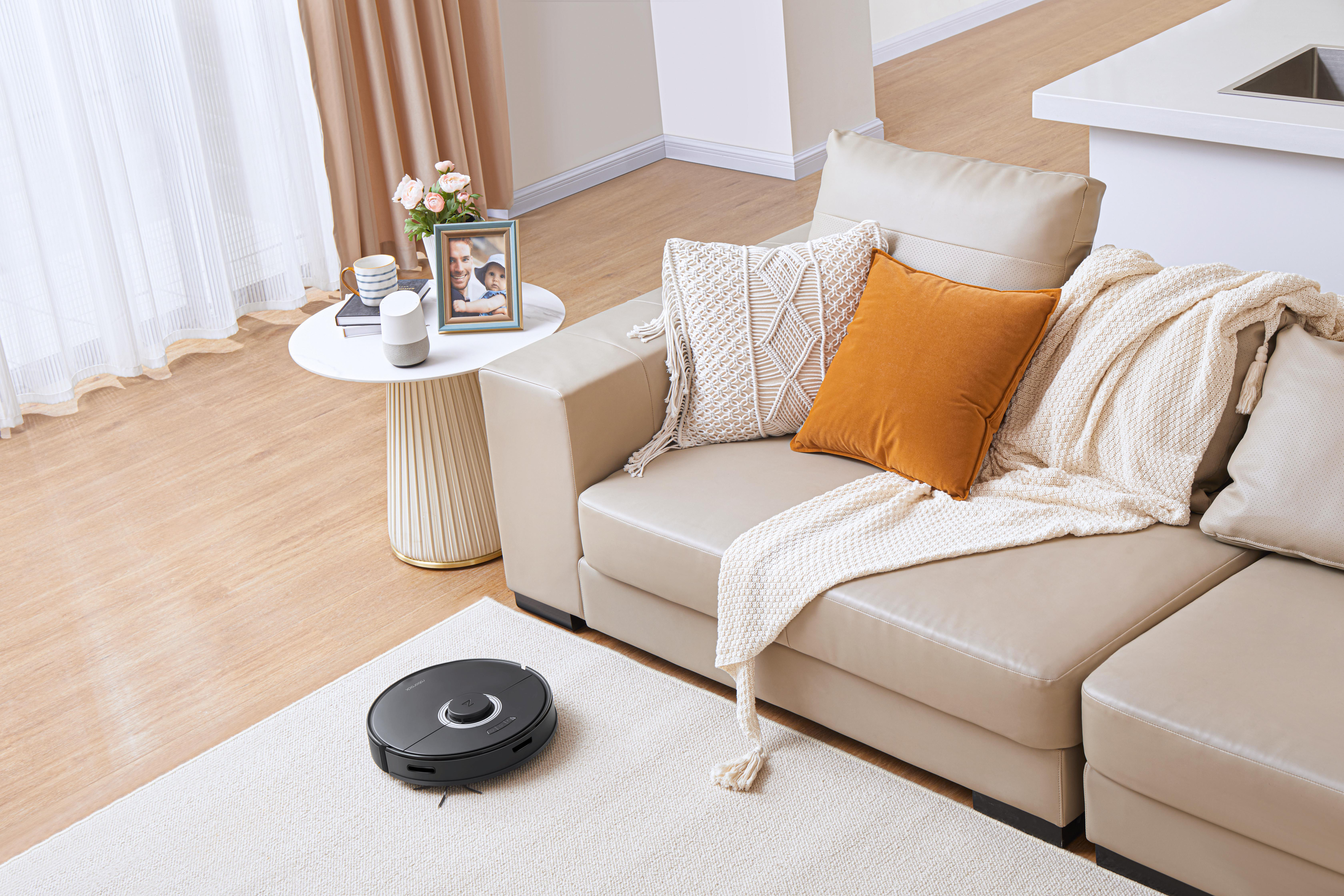 Modernes Wohnzimmer mit Staubsauger auf einem Teppich.