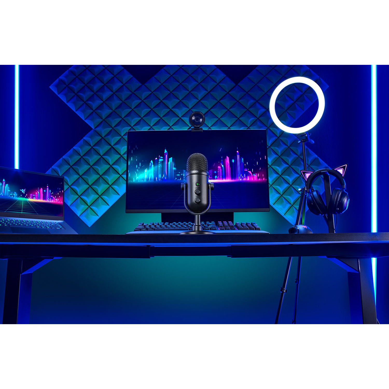 Una configuración de juego en un escritorio negro con monitor y micrófono.