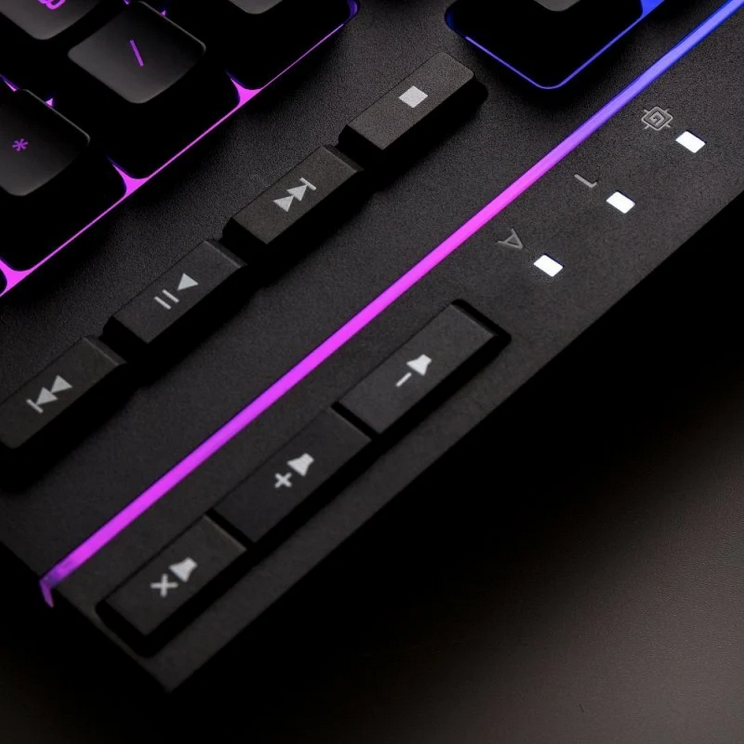 Primer plano de un teclado con teclas de control multimedia iluminadas con luces moradas y azules.