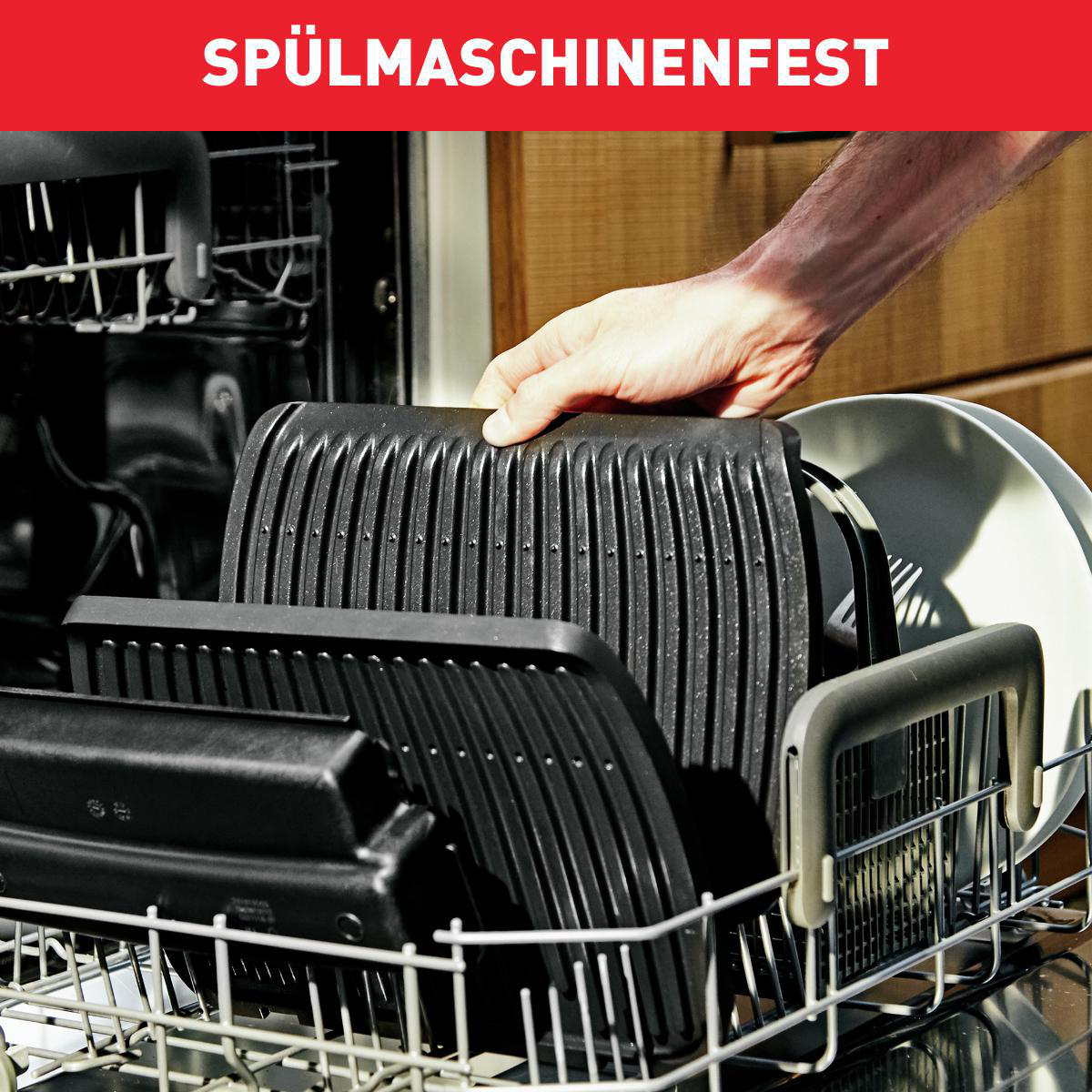 Geschirrspüler mit Grillplatten. Hand platziert eine Platte.