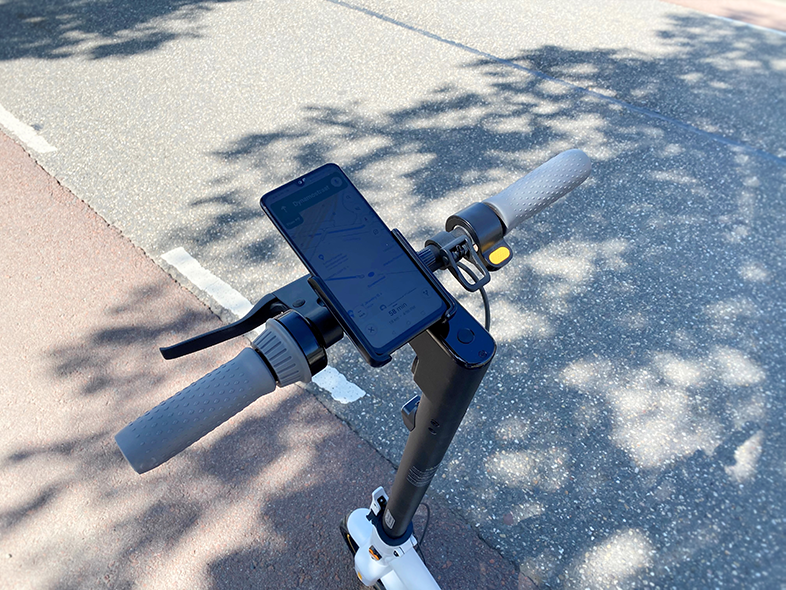 Egy okostelefon navigációs térképpel egy elektromos roller kormányán.