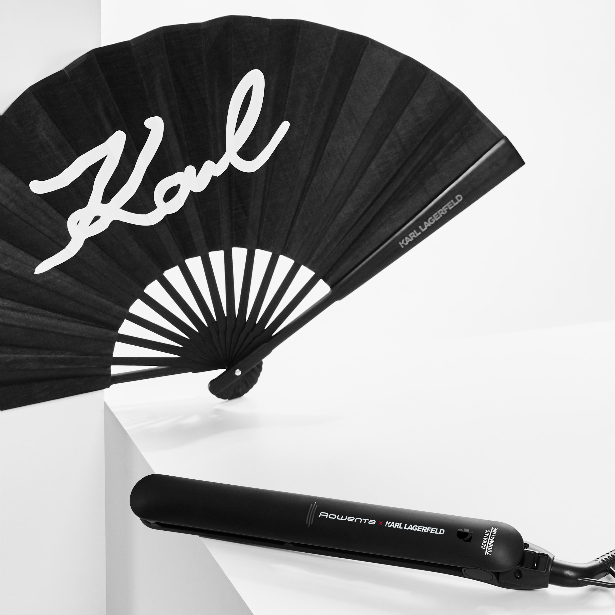 Schwarzer Fächer mit Karl-Lagerfeld-Logo und Haarglätter auf weißer Oberfläche.