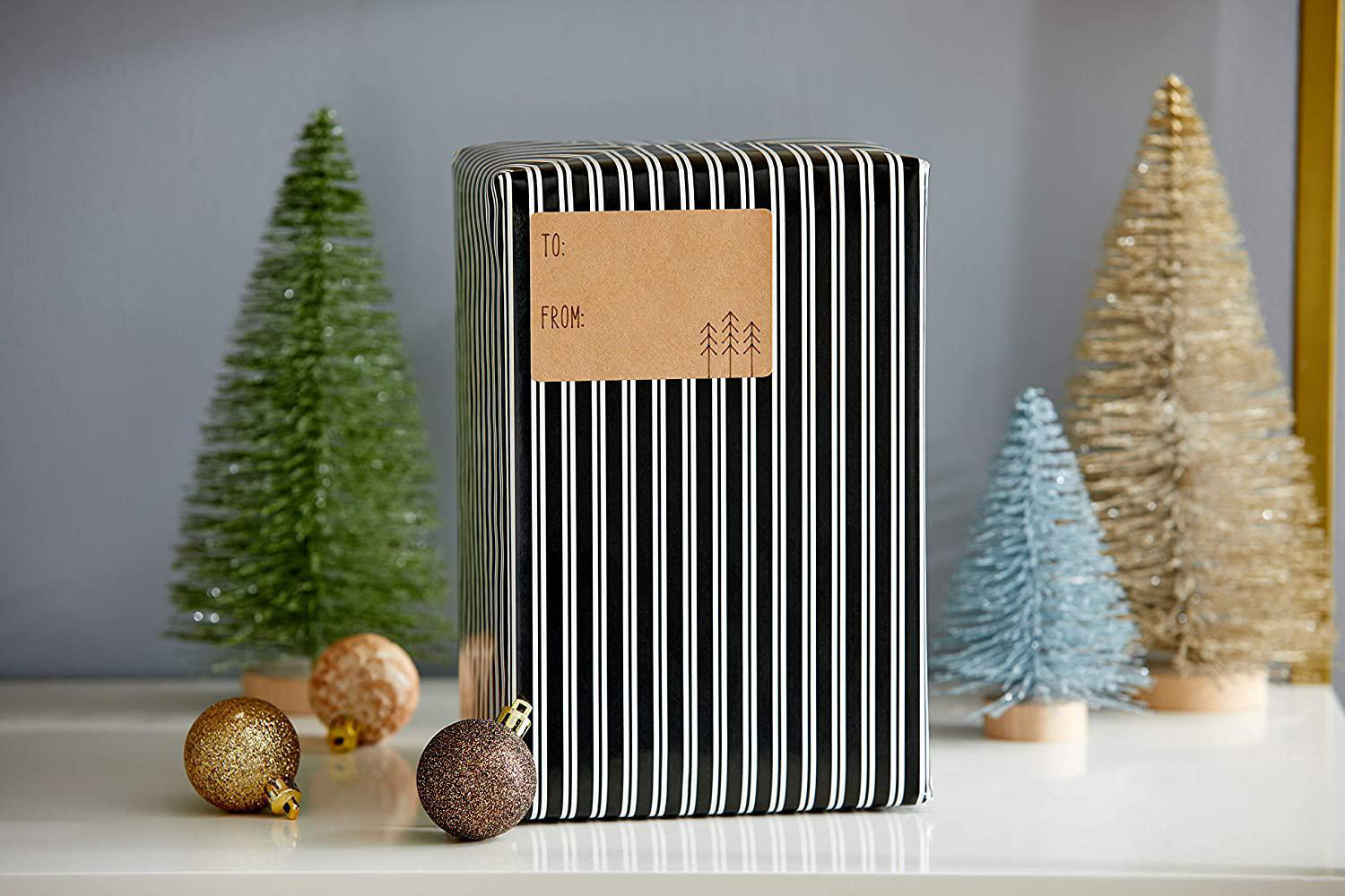 Ein verpacktes Geschenk mit Anhänger und einigen dekorativen Bäumen.