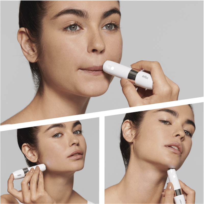A woman is using a facial hair removal device.