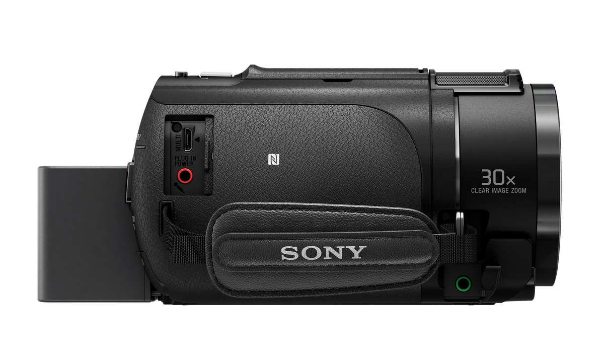Cámara de video negra. Marca Sony. Tiene un asa y botones. Fondo blanco.