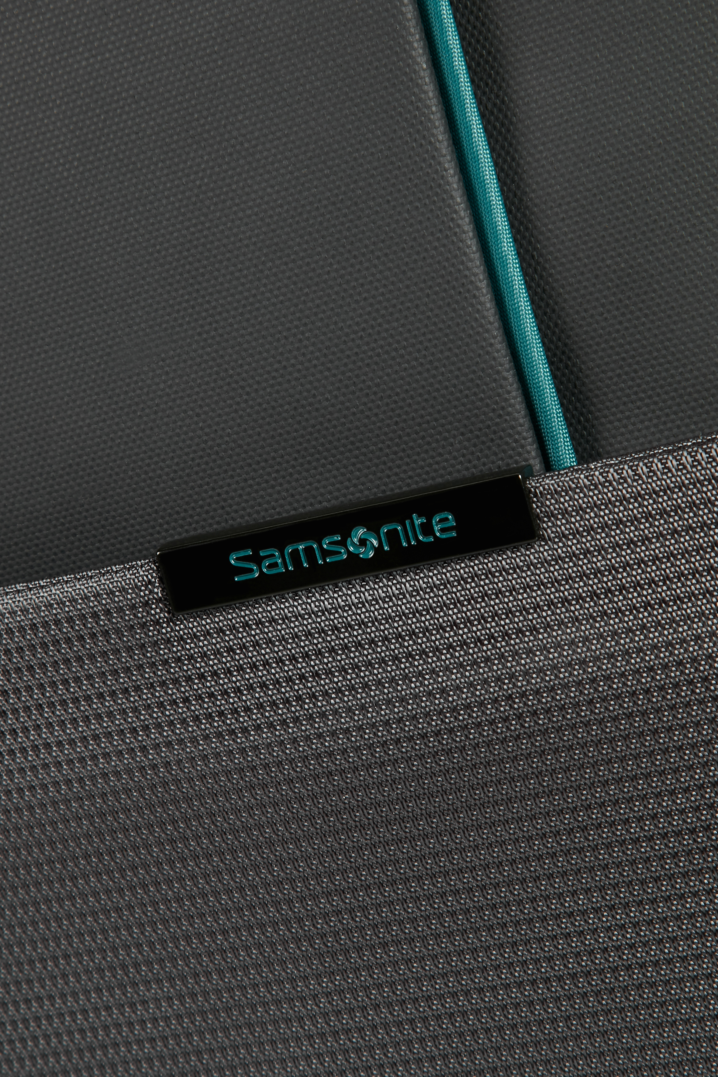 Turkuaz detaylı siyah bir Samsonite bavul etiketinin yakın çekimi.