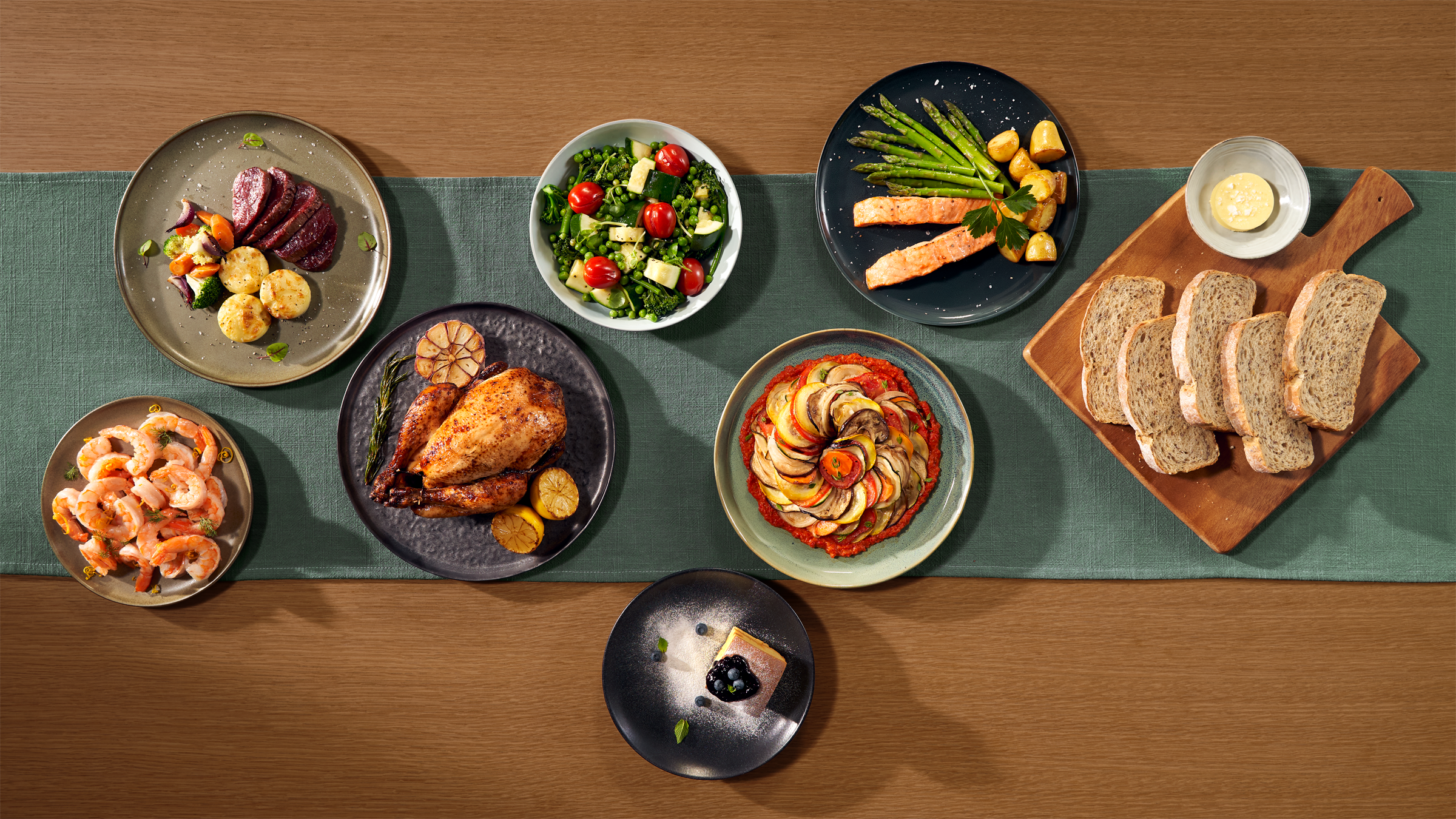 Overzicht van verschillende gerechten, waaronder vlees, salade en brood.