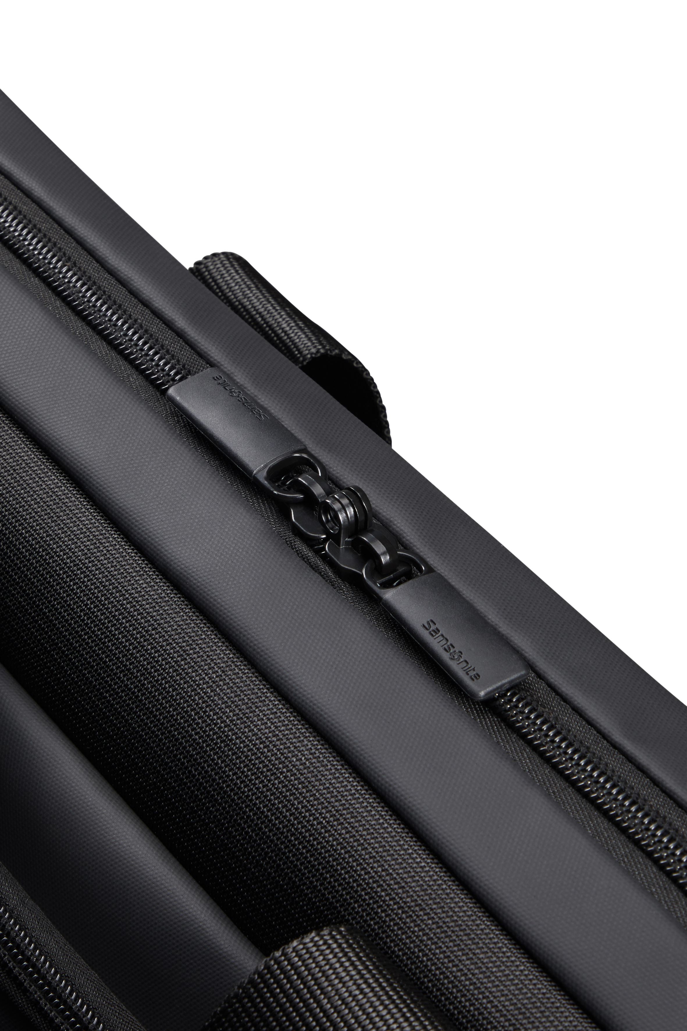 Samsonite logosu fermuar çekme üzerinde bulunan siyah bir çanta fermuarının yakın çekimi.