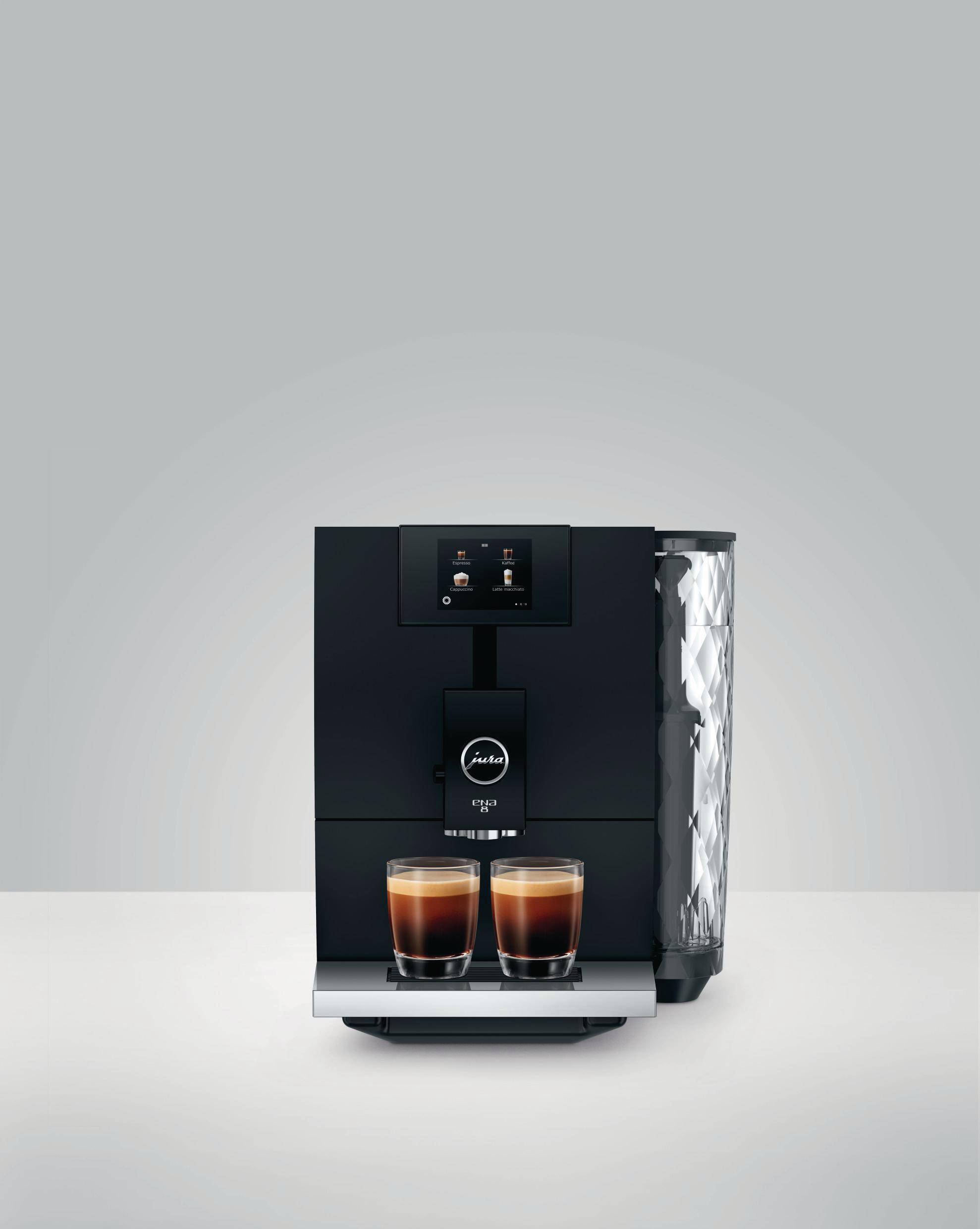 Schwarze Jura Espressomaschine mit zwei Espresso-Shots in Gläsern. Hellgrauer Hintergrund.